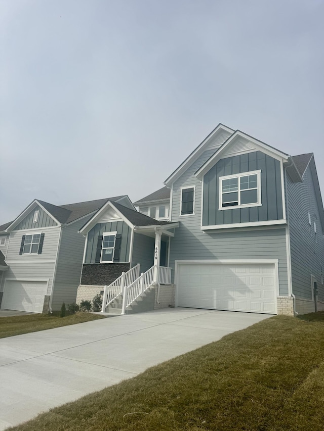 view of front facade featuring board and batten siding, a front lawn, driveway, and an attached garage