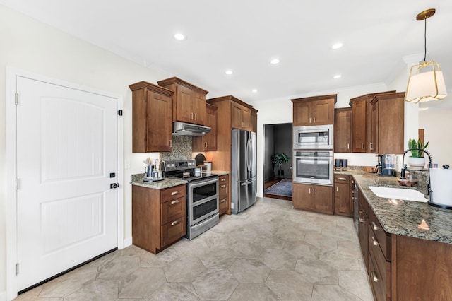 kitchen with sink, crown molding, dark stone countertops, hanging light fixtures, and stainless steel appliances