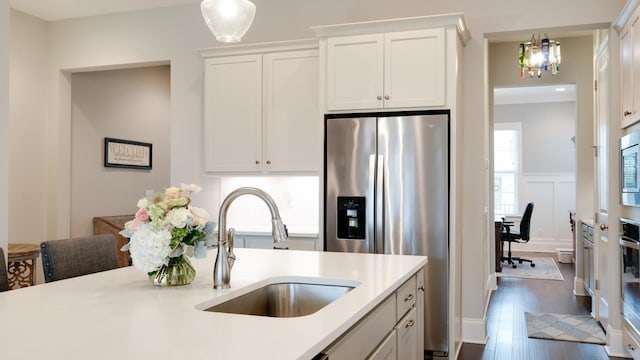 kitchen featuring pendant lighting, appliances with stainless steel finishes, sink, and white cabinets