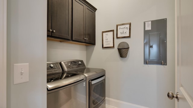 laundry area featuring cabinets, washing machine and clothes dryer, and electric panel