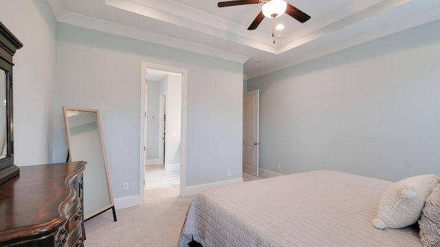 bedroom with light carpet, ceiling fan, and a tray ceiling