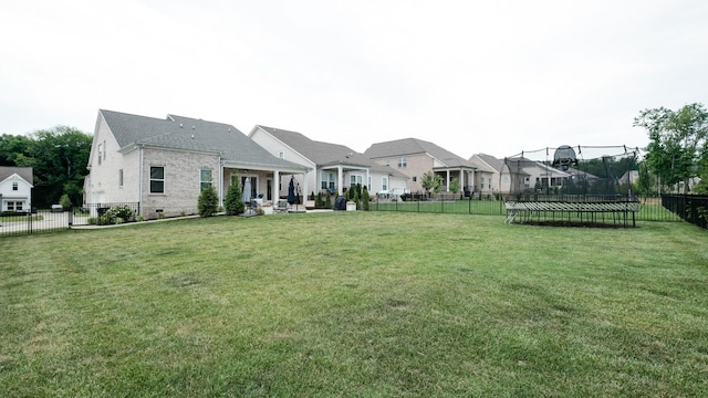 view of yard with a trampoline and a patio area