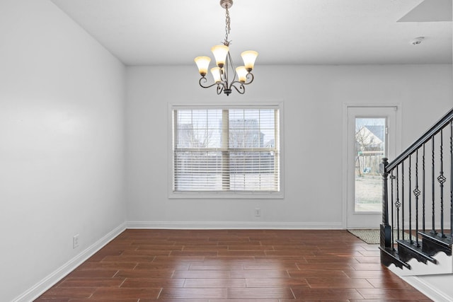 unfurnished dining area with dark hardwood / wood-style floors and a chandelier