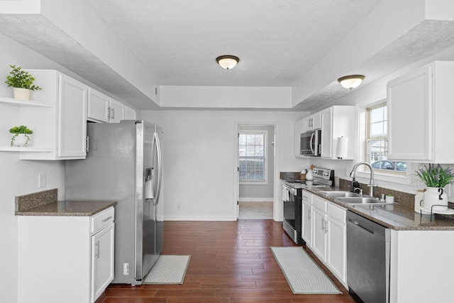 kitchen featuring a raised ceiling, white cabinetry, and appliances with stainless steel finishes