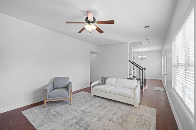 living room with dark hardwood / wood-style floors and ceiling fan with notable chandelier