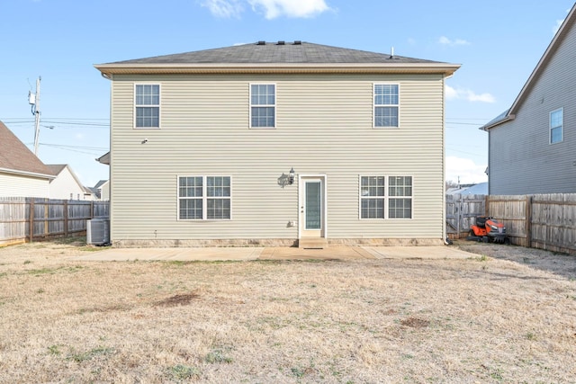 rear view of property with a yard, cooling unit, and a patio area