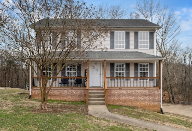 view of front of home with covered porch and a front lawn