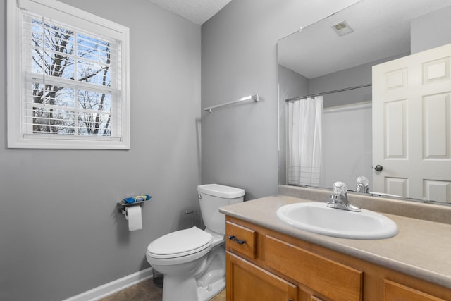 bathroom featuring vanity, a textured ceiling, curtained shower, and toilet