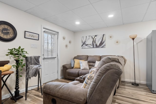 living room featuring light hardwood / wood-style flooring and a paneled ceiling