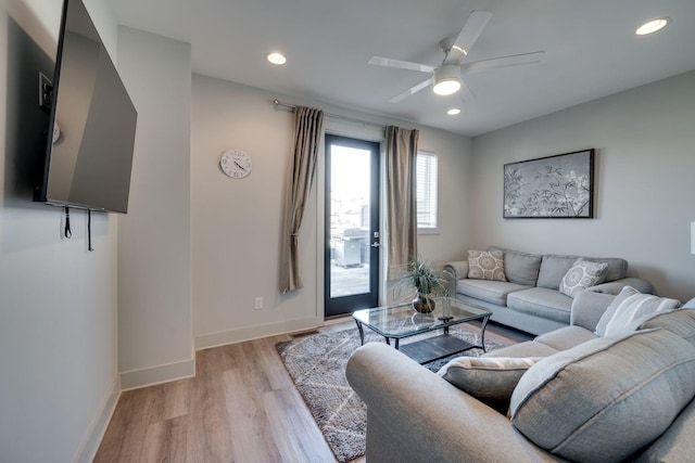 living room featuring light hardwood / wood-style flooring and ceiling fan