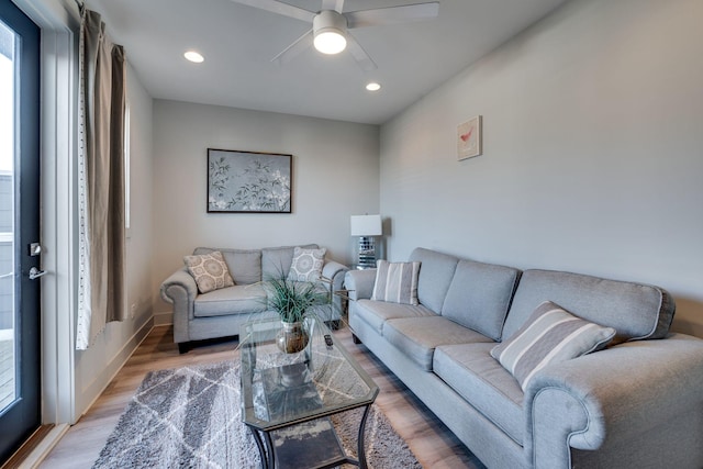 living room featuring wood-type flooring and ceiling fan