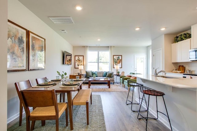 dining space with sink and light hardwood / wood-style flooring