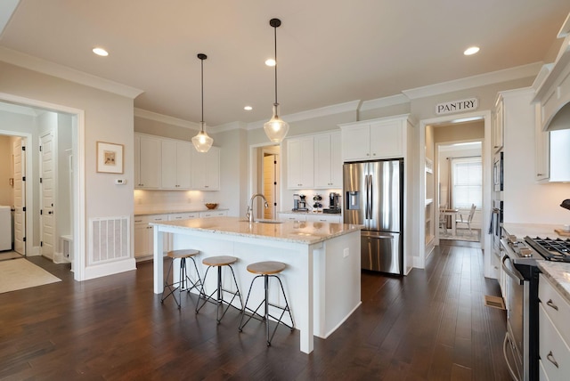 kitchen with sink, stainless steel appliances, an island with sink, and white cabinets