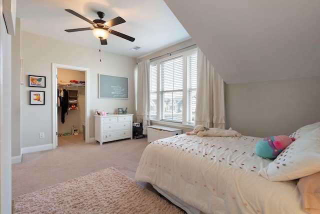 carpeted bedroom with ceiling fan, a spacious closet, and a closet