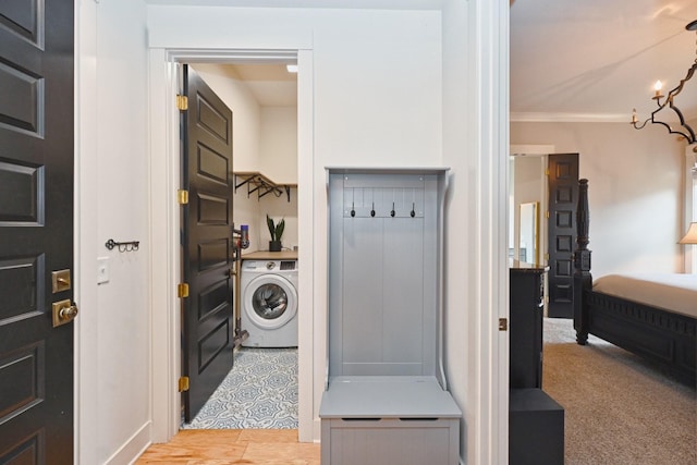 washroom with ornamental molding and washer / dryer