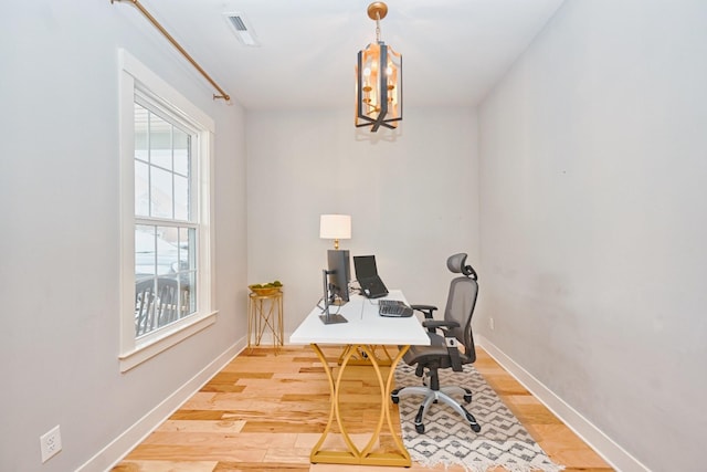 office space with hardwood / wood-style floors and a chandelier