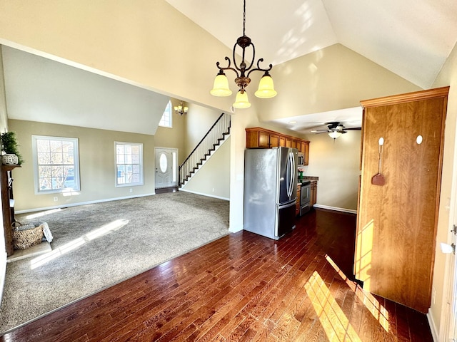 kitchen with dark hardwood / wood-style flooring, high vaulted ceiling, stainless steel appliances, and a chandelier