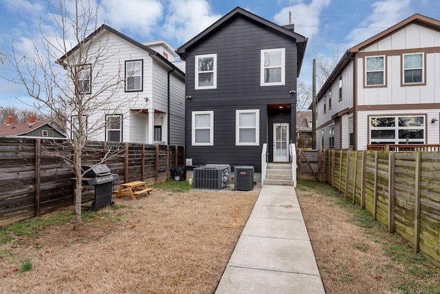 view of front of house featuring central AC and a front lawn