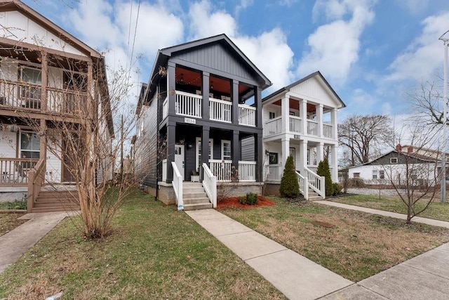 view of front of home with a porch, a balcony, and a front lawn