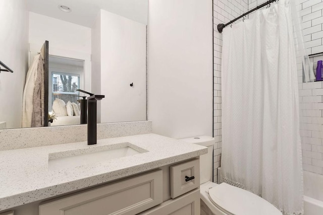 full bathroom with vanity, shower / tub combo, and toilet