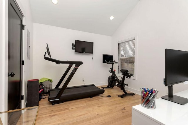 exercise room with vaulted ceiling and hardwood / wood-style floors