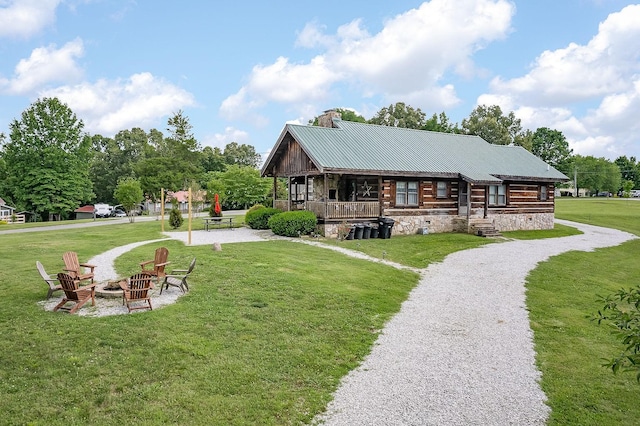 rear view of house featuring a lawn and an outdoor fire pit