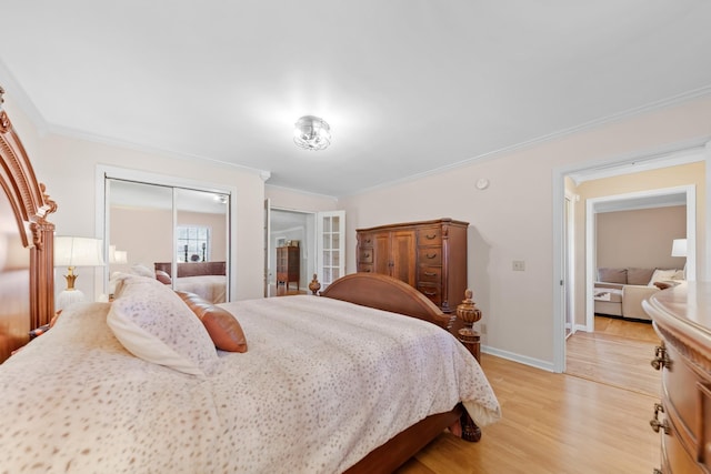 bedroom featuring light hardwood / wood-style flooring, ornamental molding, and a closet