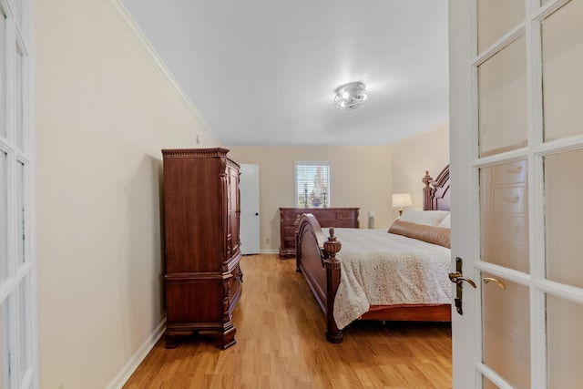 bedroom with ornamental molding and light hardwood / wood-style floors