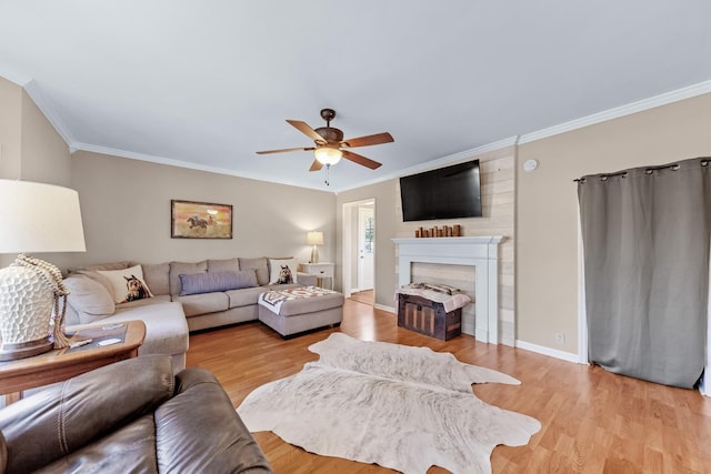 living room with a fireplace, crown molding, light hardwood / wood-style flooring, and ceiling fan