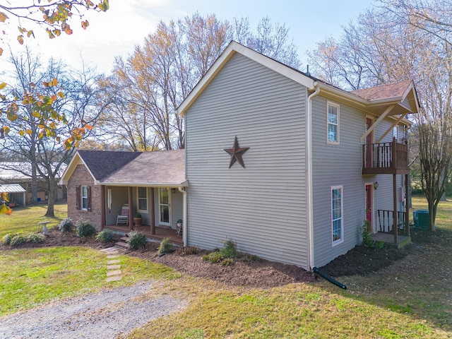 view of side of home with a yard, central AC, and a porch