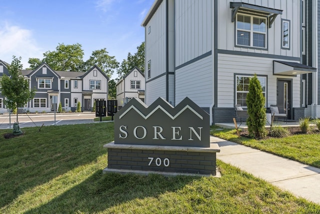 community / neighborhood sign with a residential view and a yard