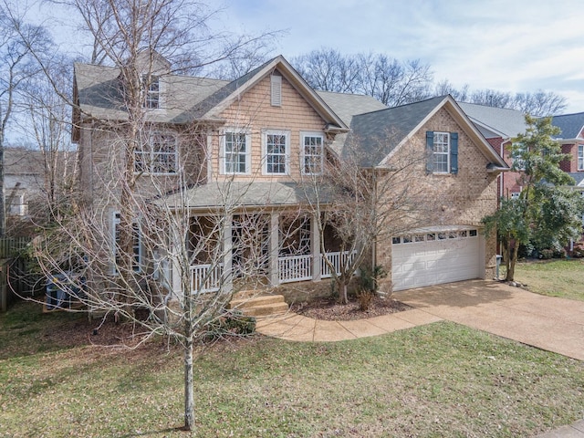 view of front of home with a garage, a front yard, and covered porch