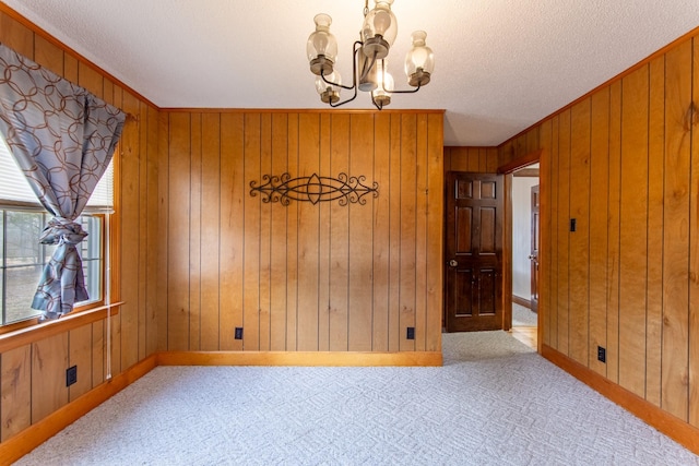 unfurnished dining area featuring light carpet, a notable chandelier, and wood walls