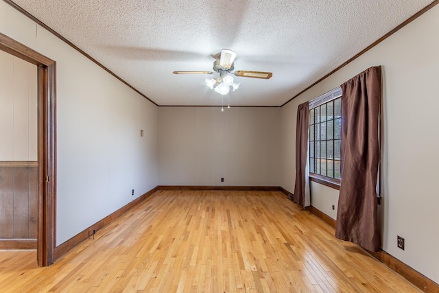 empty room with crown molding, ceiling fan, light hardwood / wood-style floors, and a textured ceiling