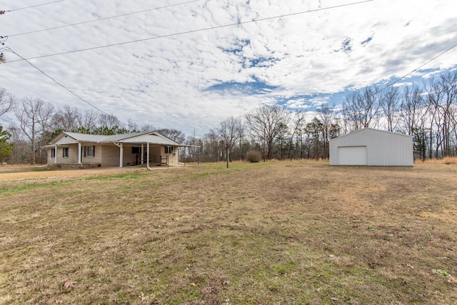 view of yard with a garage, an outdoor structure, and covered porch