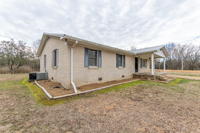 view of side of property with central AC, a porch, and a lawn