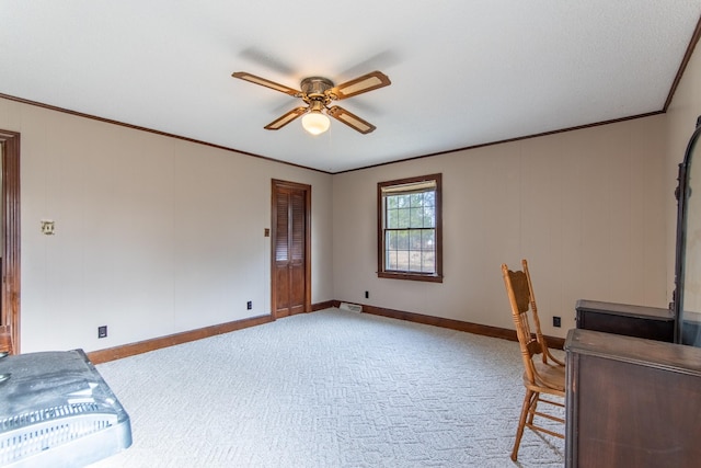 unfurnished office featuring crown molding, light colored carpet, and ceiling fan