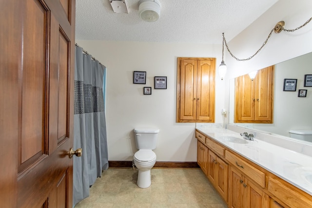 bathroom featuring vanity, a textured ceiling, toilet, and walk in shower