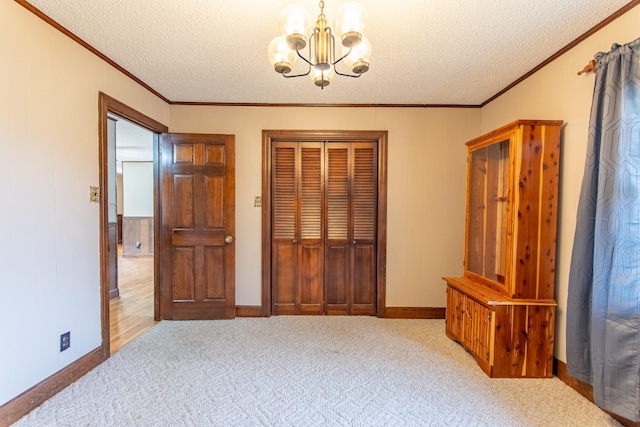 carpeted bedroom featuring ornamental molding, an inviting chandelier, a textured ceiling, and a closet