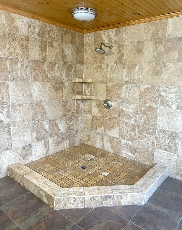 bathroom featuring a tile shower and wood ceiling