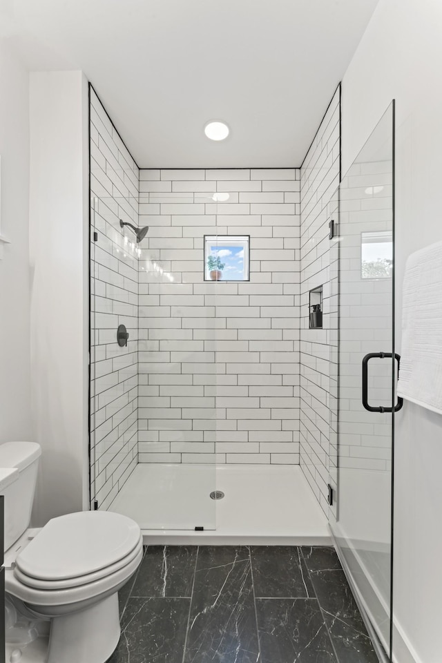 bathroom with toilet and an enclosed shower