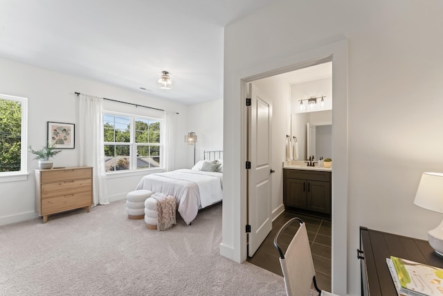 bedroom featuring connected bathroom, sink, and carpet floors