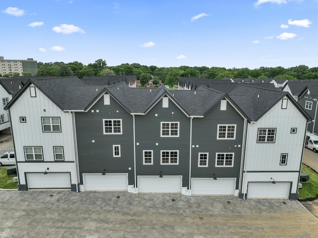 back of property with an attached garage, driveway, and board and batten siding