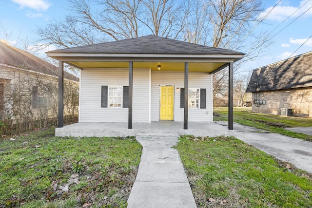 view of front of house with central AC unit and a front lawn