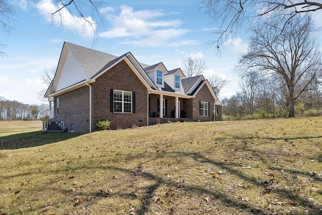 view of front of home with covered porch, a front lawn, central AC, and brick siding