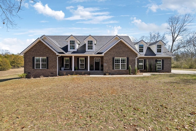 cape cod home featuring covered porch, brick siding, crawl space, and a front yard