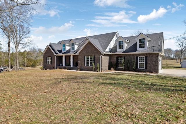 cape cod home with brick siding and a front lawn