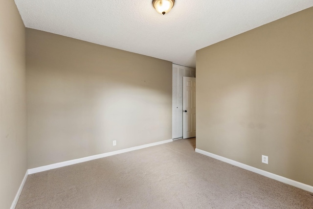 unfurnished room with light colored carpet and a textured ceiling