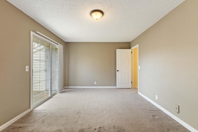 unfurnished room featuring light colored carpet and a textured ceiling