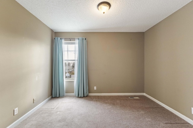 carpeted empty room with a textured ceiling